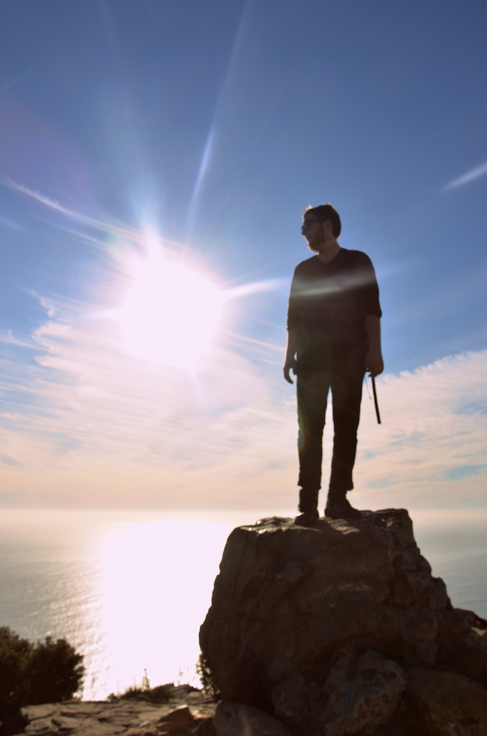 Man standing on mountain with sunset